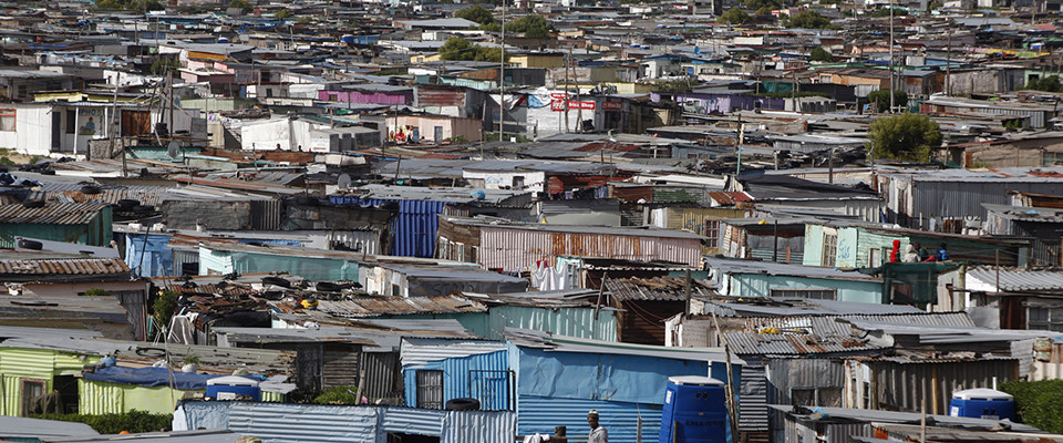 Residents walk through shacks in Cape Town's crime-ridden Khayelitsha township in this picture taken July 9, 2012. At least 11 people have died at the hands of vigilantes in the township since January as angry residents, tired of poor policing, take the law into their own hands. Picture taken July 9, 2012. To match Feature SAFRICA-CRIME/  REUTERS/Mike Hutchings (SOUTH AFRICA - Tags: CRIME LAW) - RTR34VDA